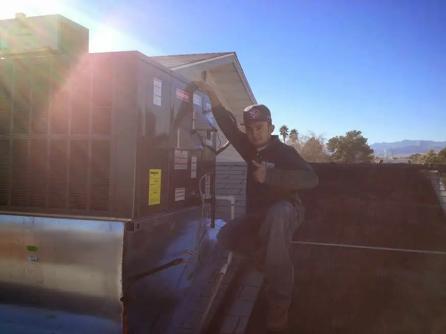 HVAC technician performing AC Tune-Up on a rooftop unit in Epsom